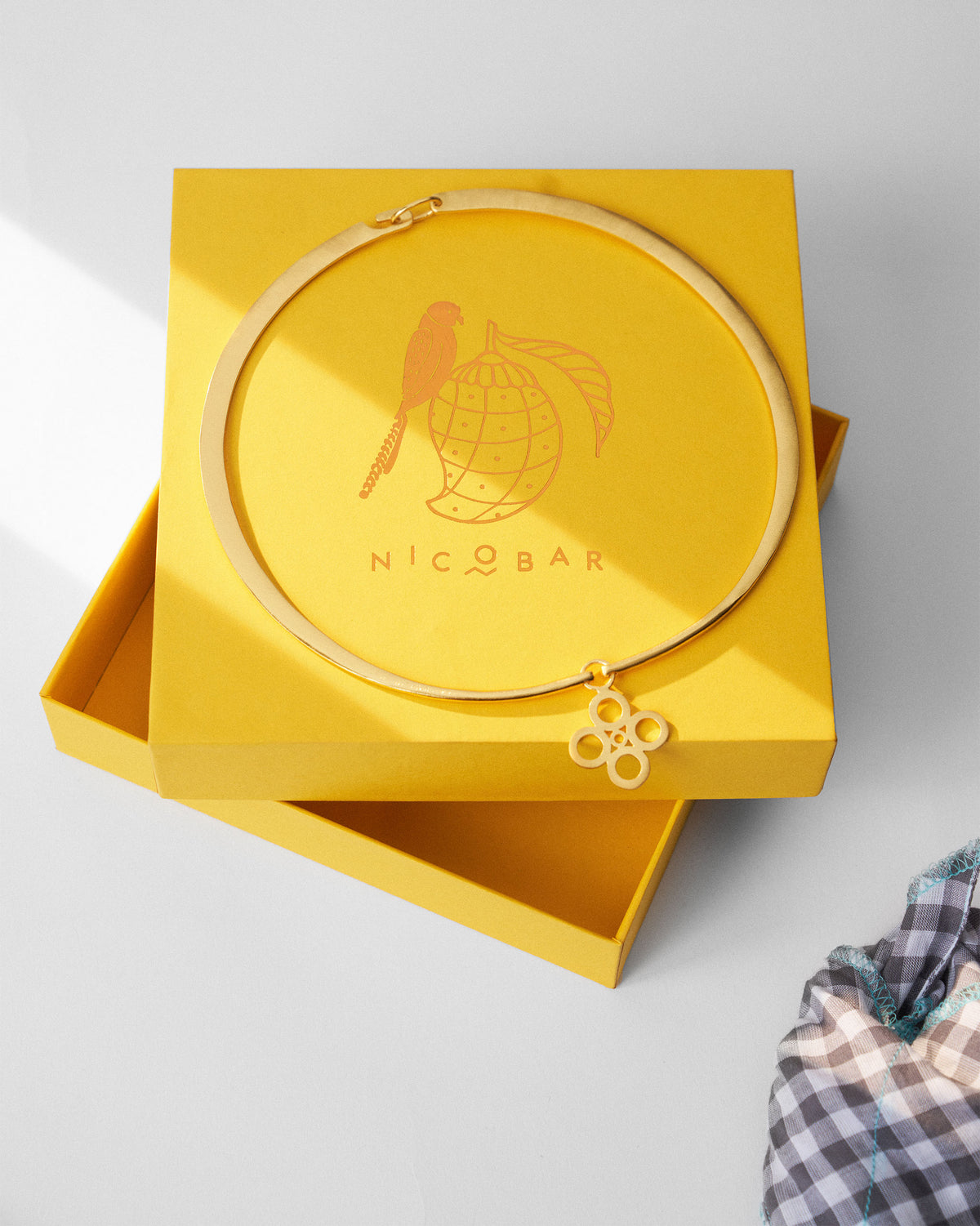 Gold sindhu choker beside a Nicobar jewellery box.