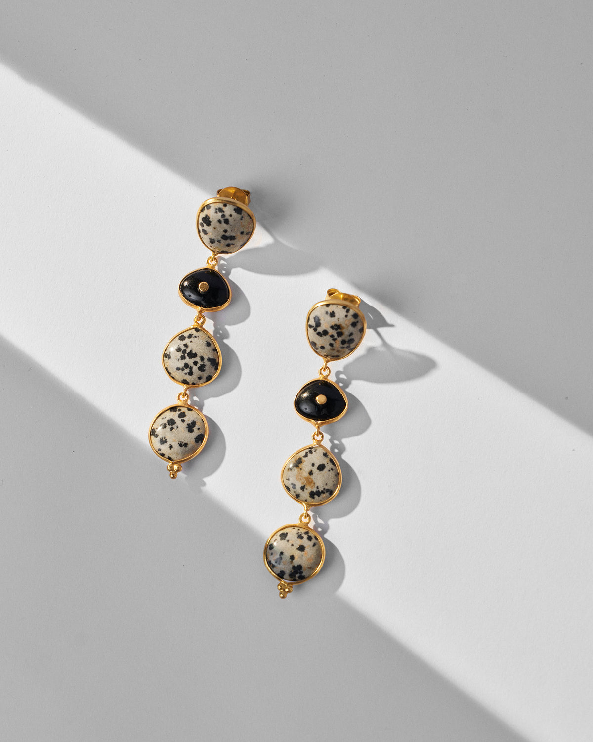 Pair of gold Mountain Danglers with speckled and black stones.
