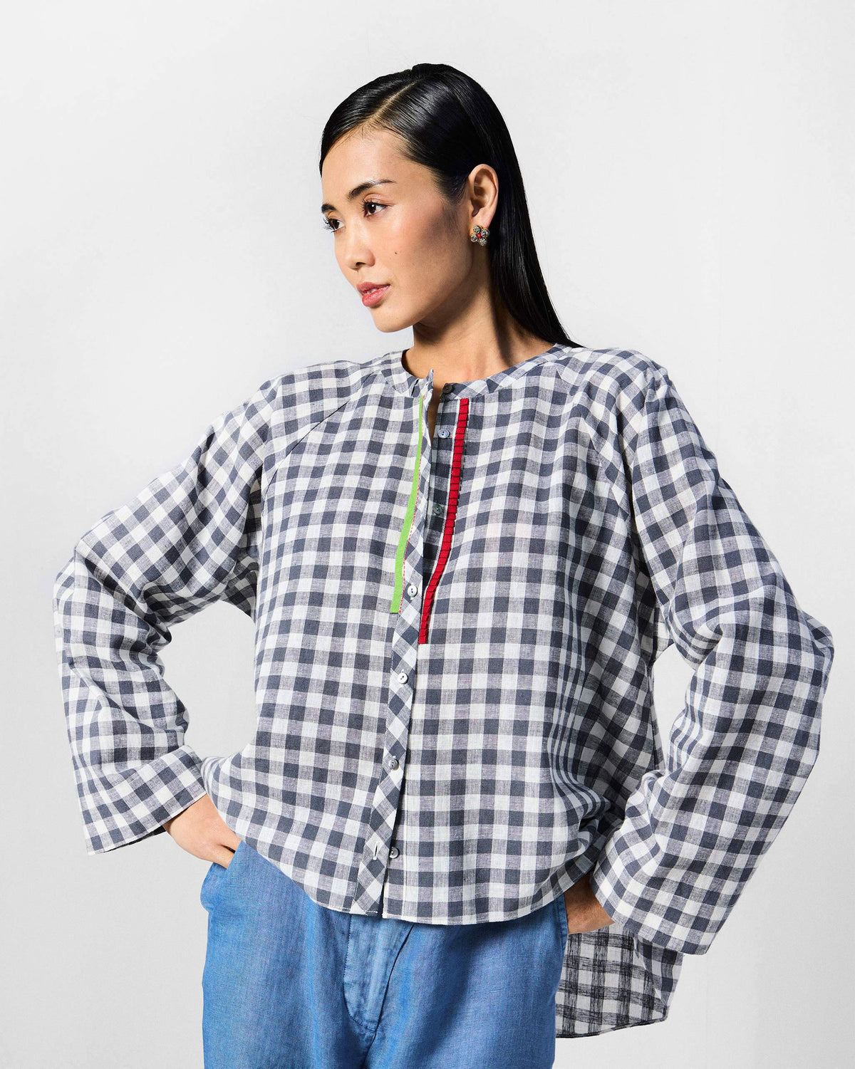 Person wearing a charcoal and white checked Zil top with lime and red trim.