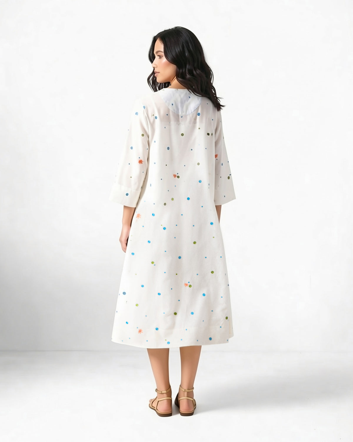 Back of an ivory Meadow dress with dot embroidery worn by a person.