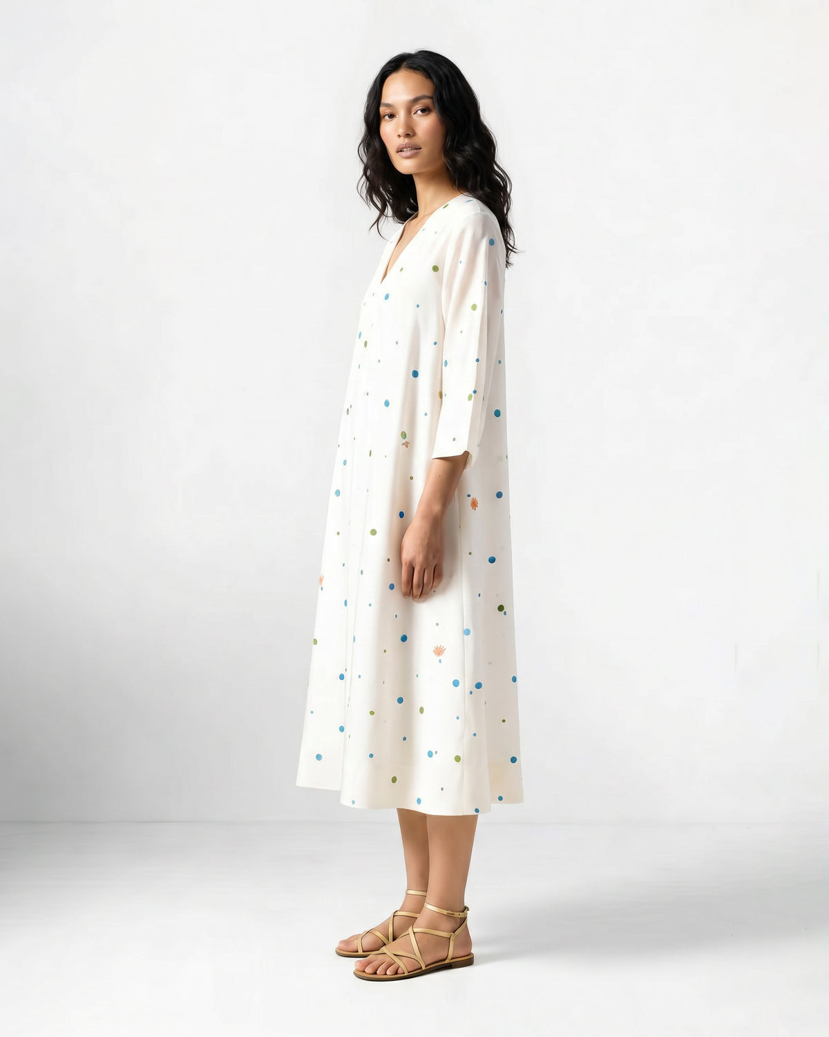 Side view of an ivory Meadow dress worn by a person.