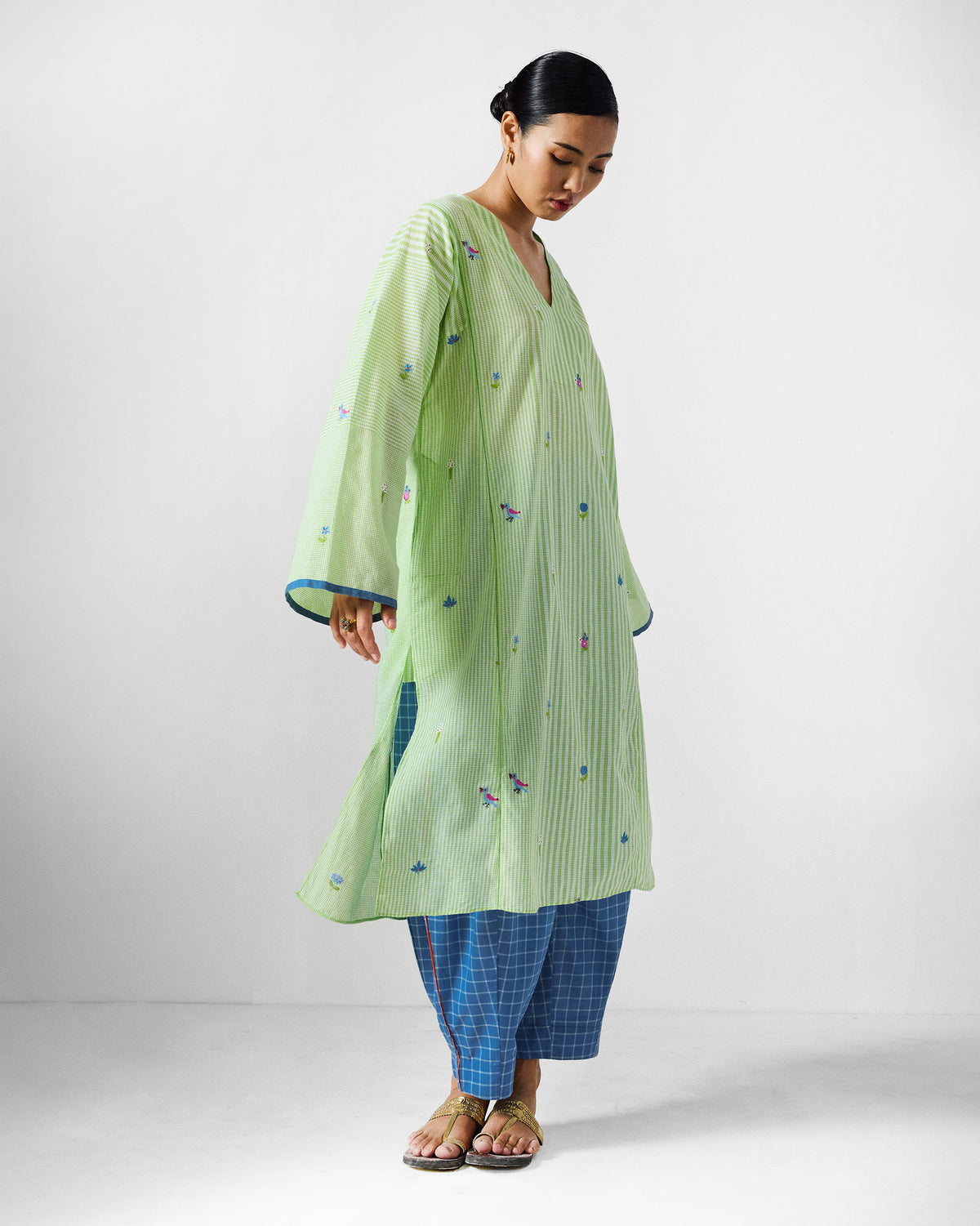 Person wearing a green and white embroidered Gigi Kurta with floral motifs.