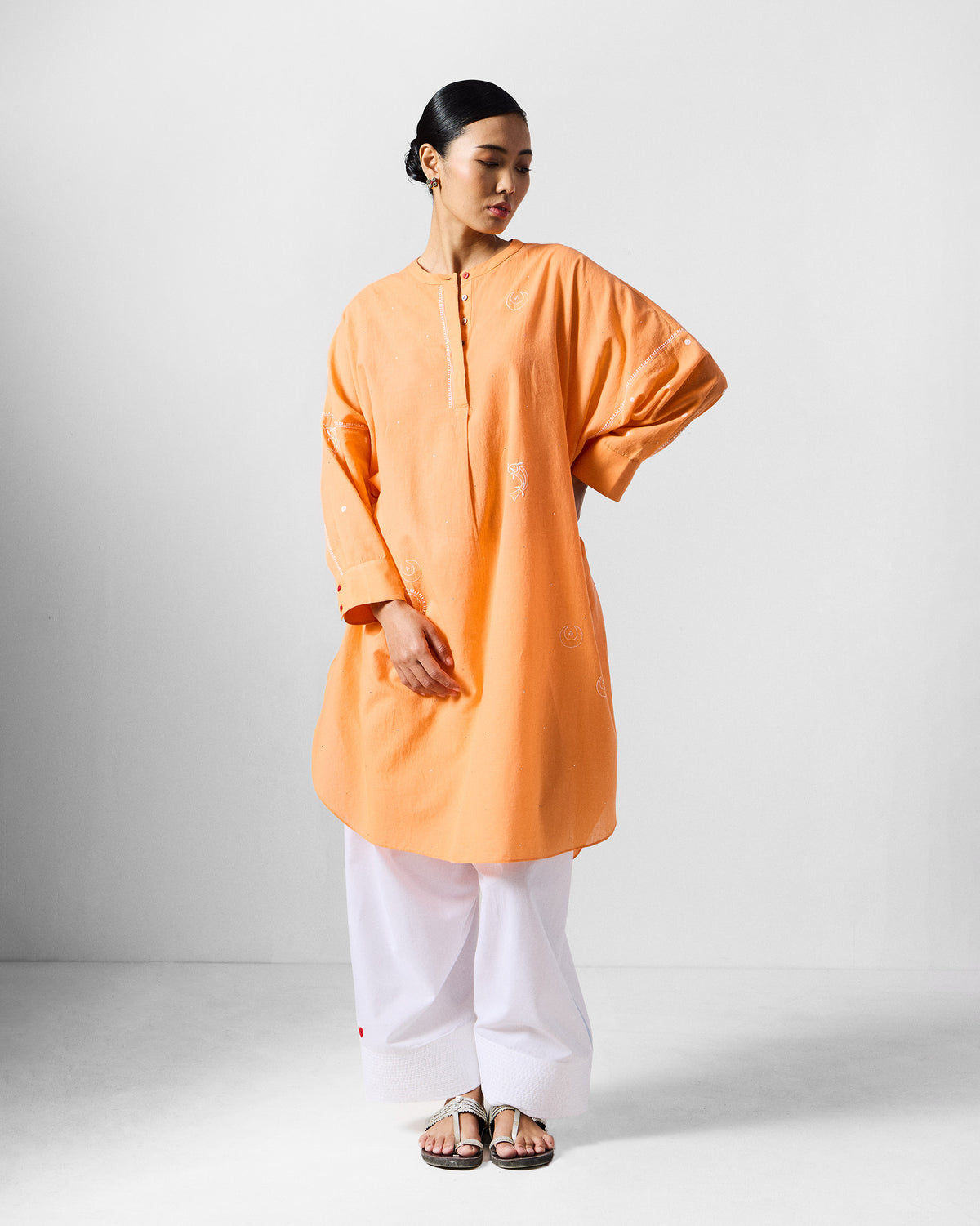 Front of an orange Lazy Sunday tunic with a mandarin collar and longline hem.