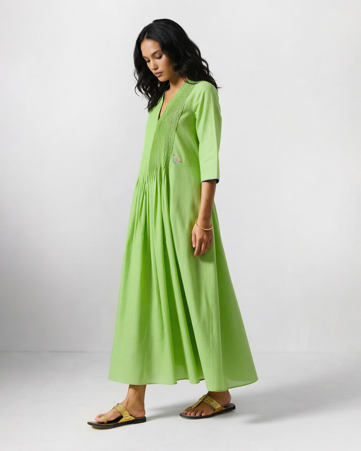 Side view of a light green Yara dress with pin tucks down the bodice.