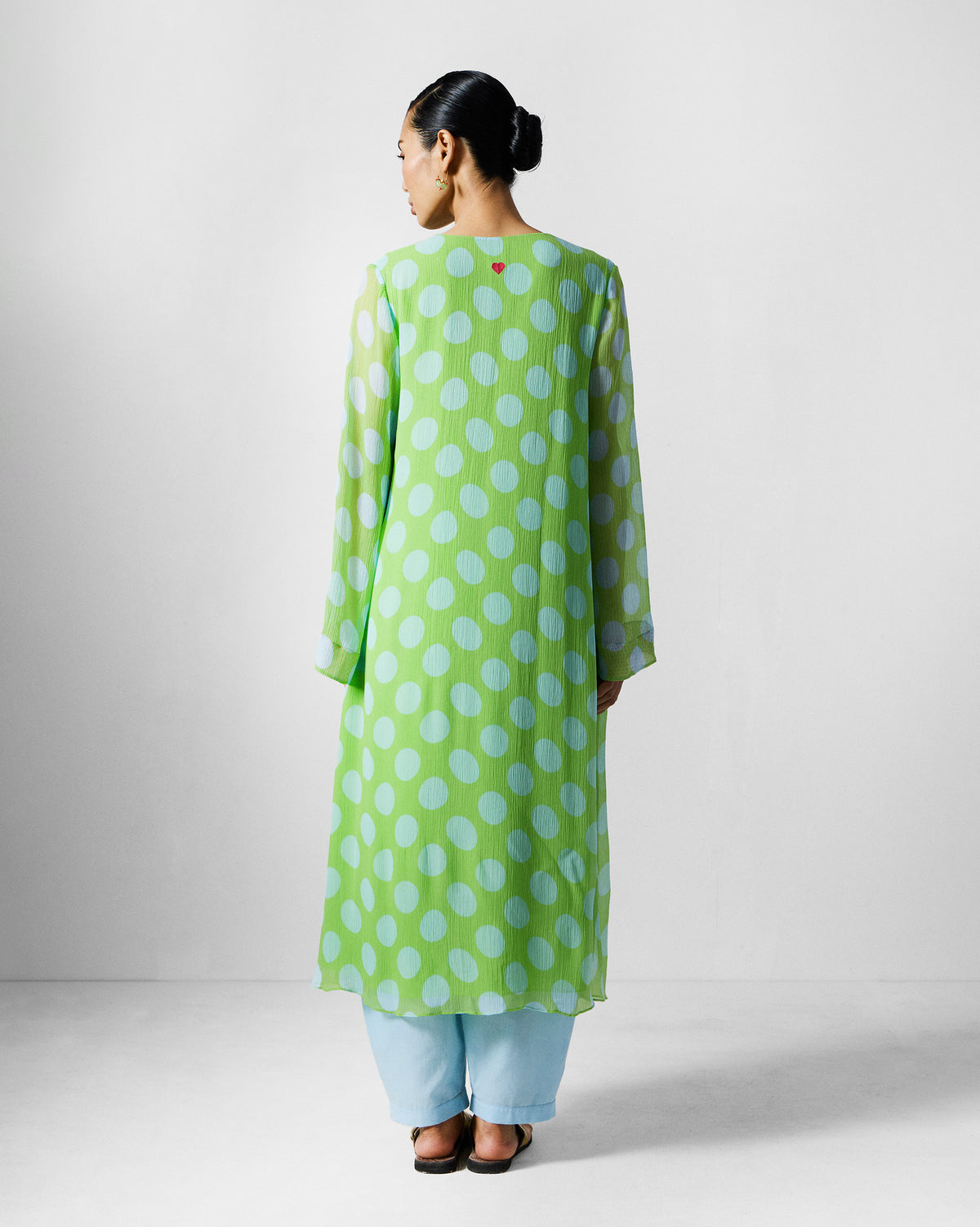 Back of a green and blue dotted kurta with a red heart at the neck.