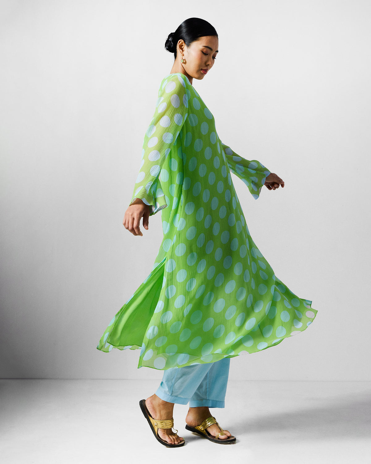 Person wearing a green and blue dotted Pleated Bell Sleeve kurta in motion.