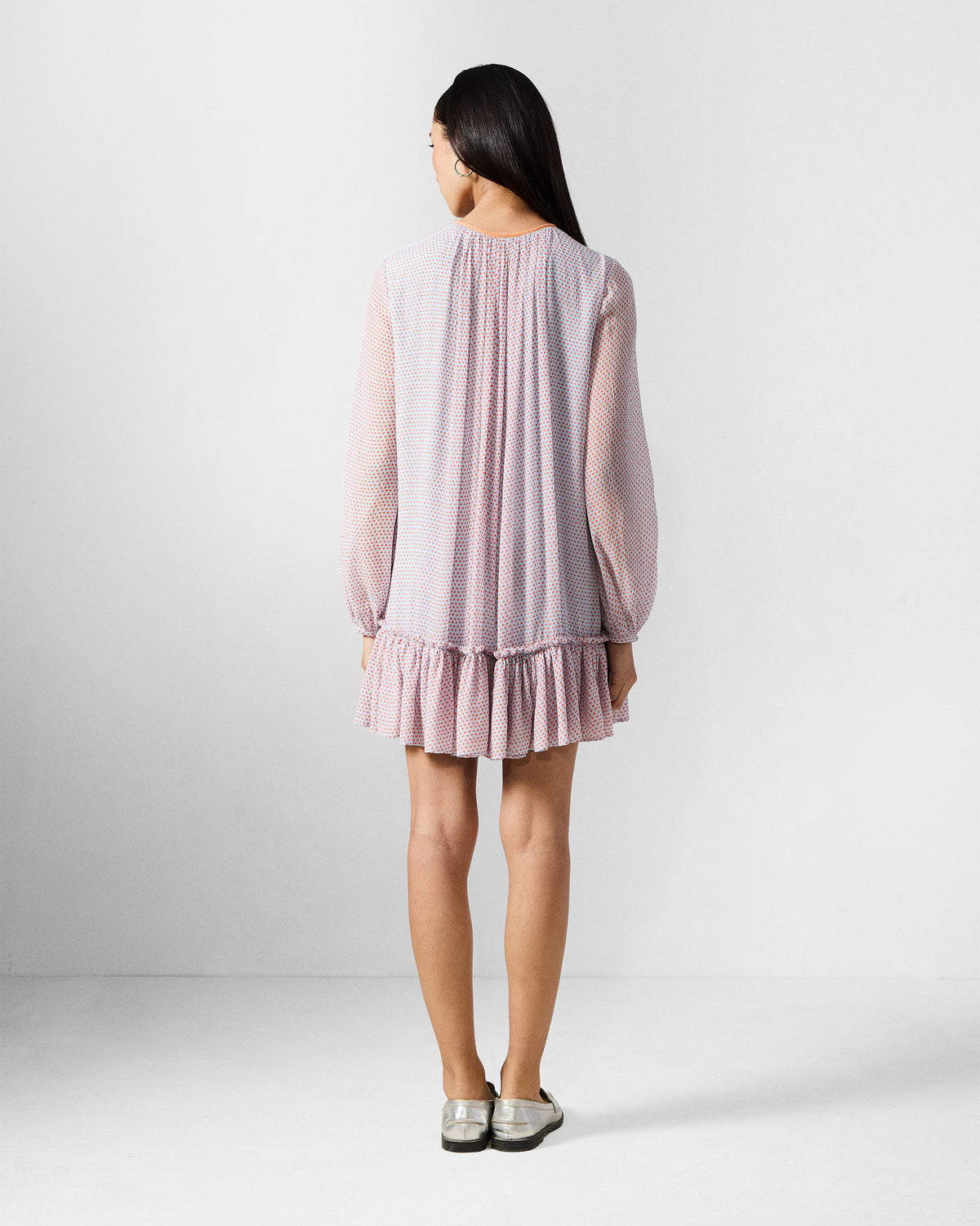 Back of a blue and orange printed Siya dress with a ruffled hem.
