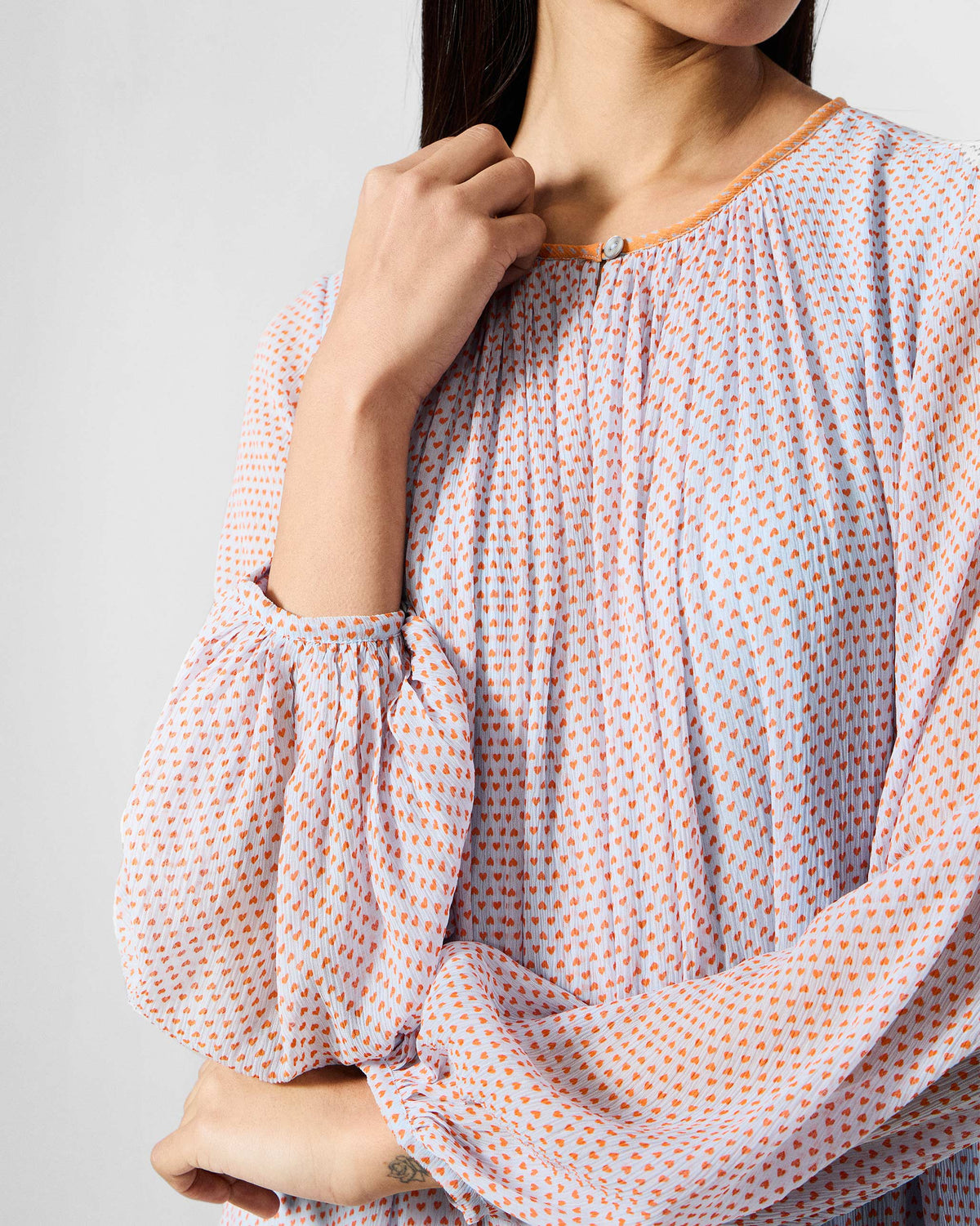 Close-up of a blue and orange printed Siya dress with a keyhole neck and gathered sleeves.