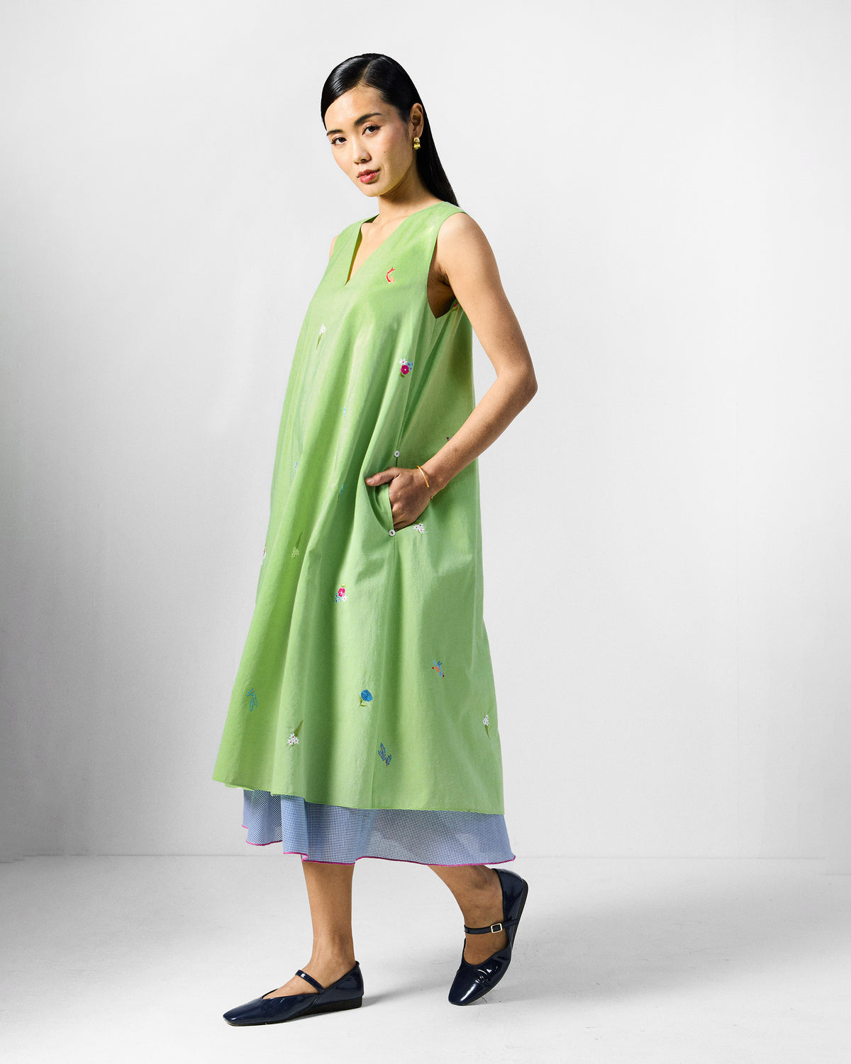 Side view of the lime green Ezra Dress with a hand in a side pocket.