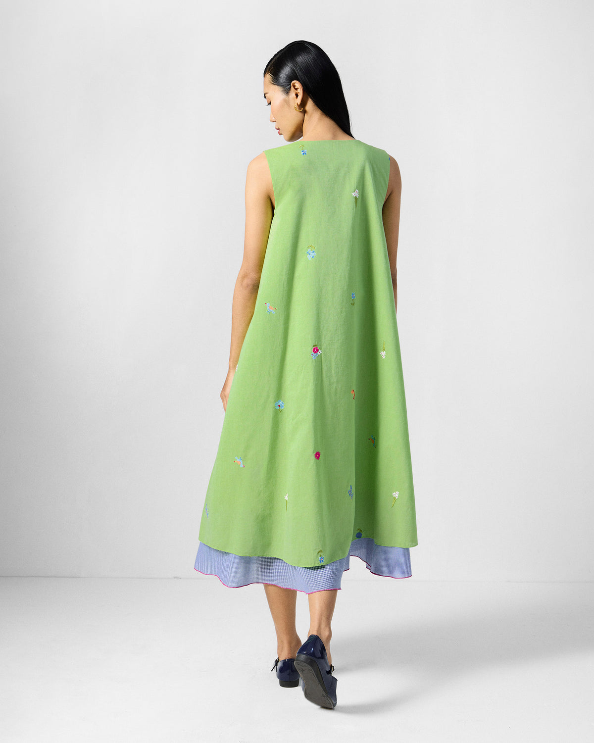 Back of the lime green Ezra Dress with small embroidered motifs worn by a person.