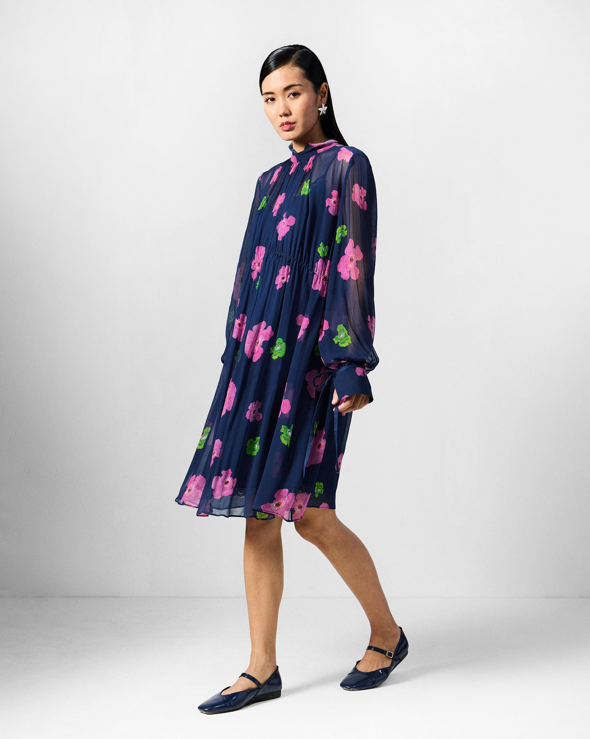 Person wearing a navy Raya dress with pink and lime florals.