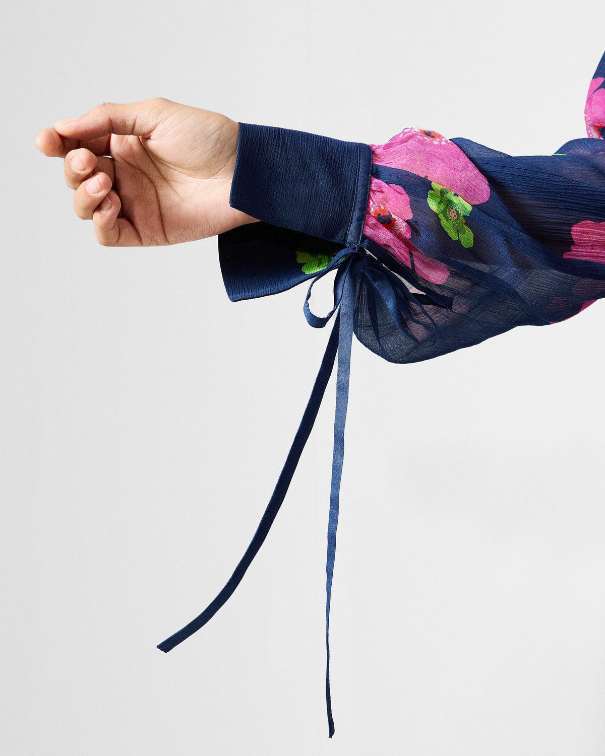 Close-up of a navy Raya dress cuff with a ribbon tie.