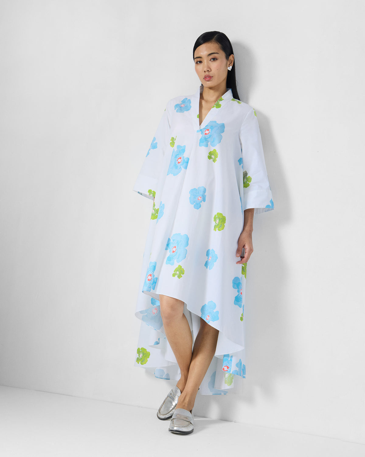 Person wearing a white Nava Dress with blue and lime poppies.