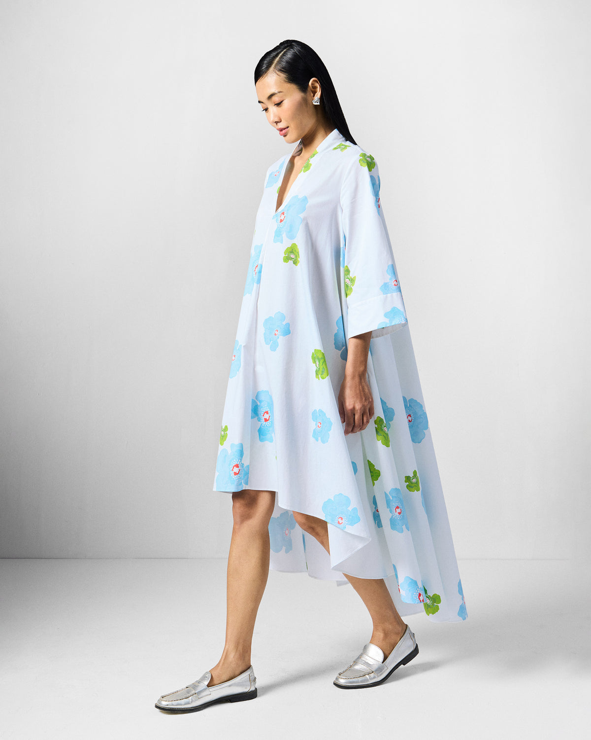 Side view of a white Nava Dress showing the longer back hem.