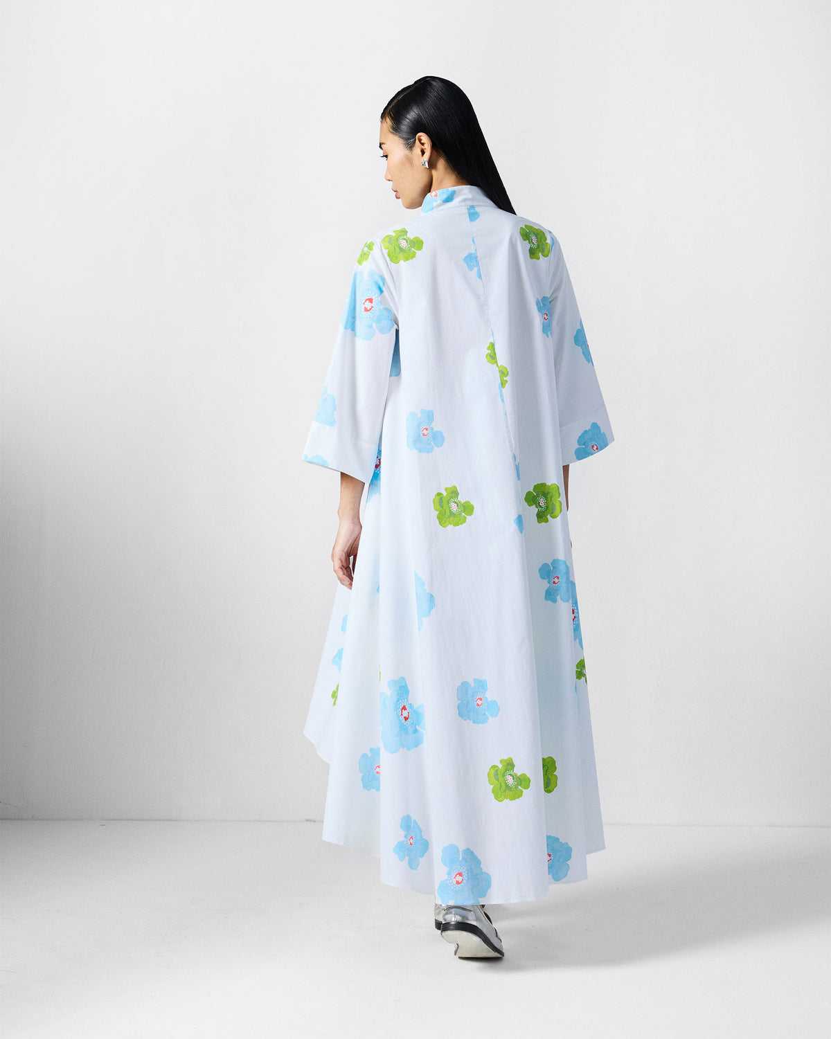 Back of a white Nava Dress with blue and lime poppies.