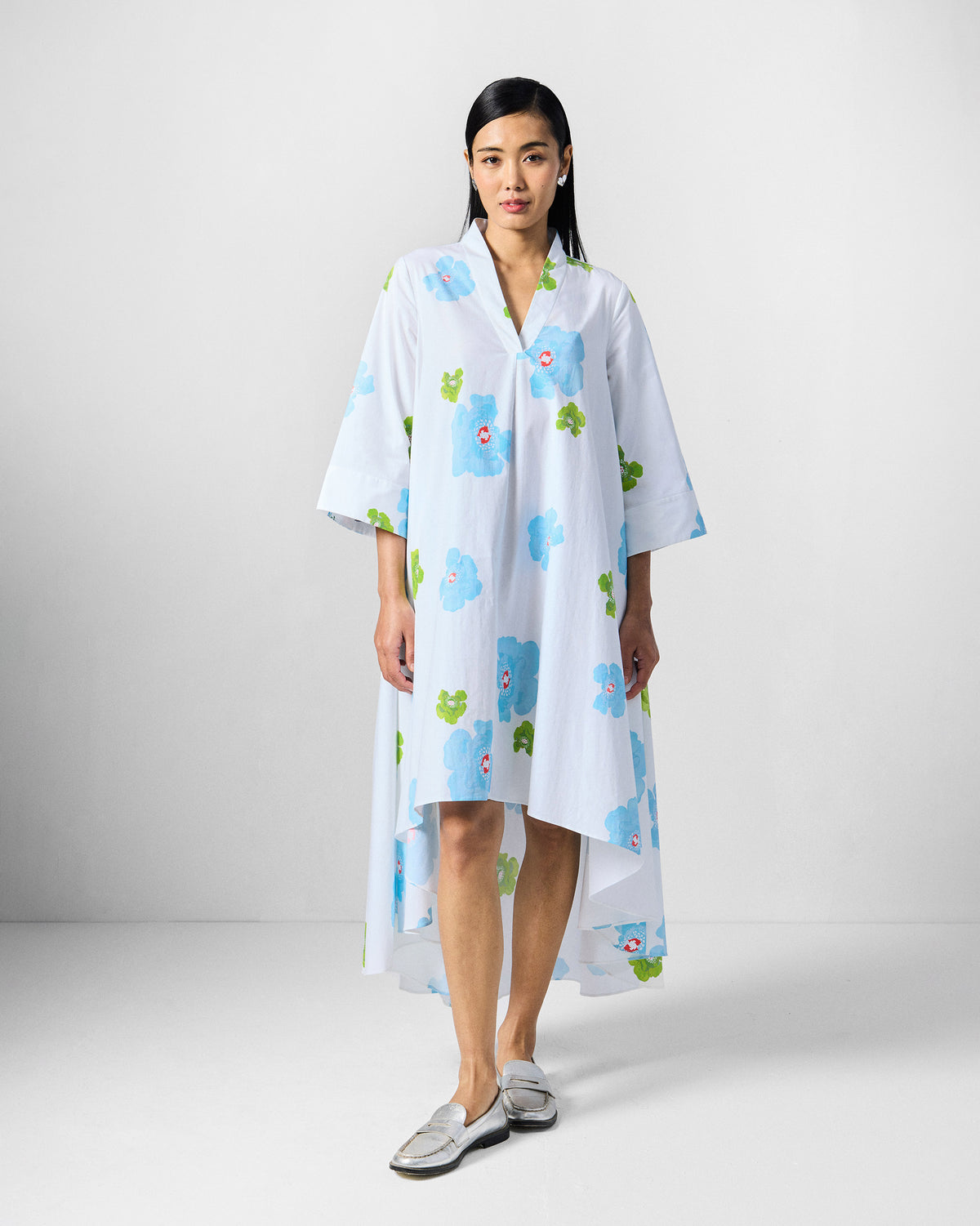 Person wearing a white Nava Dress with a high-low hem.
