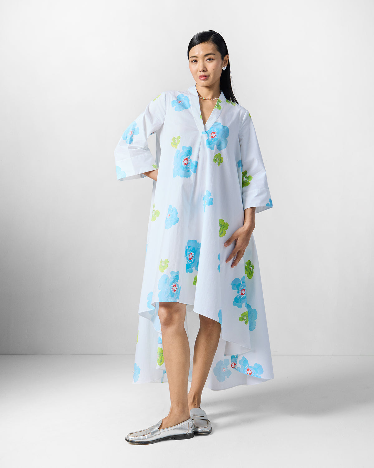 Person wearing a white Nava Dress with blue and lime floral print.