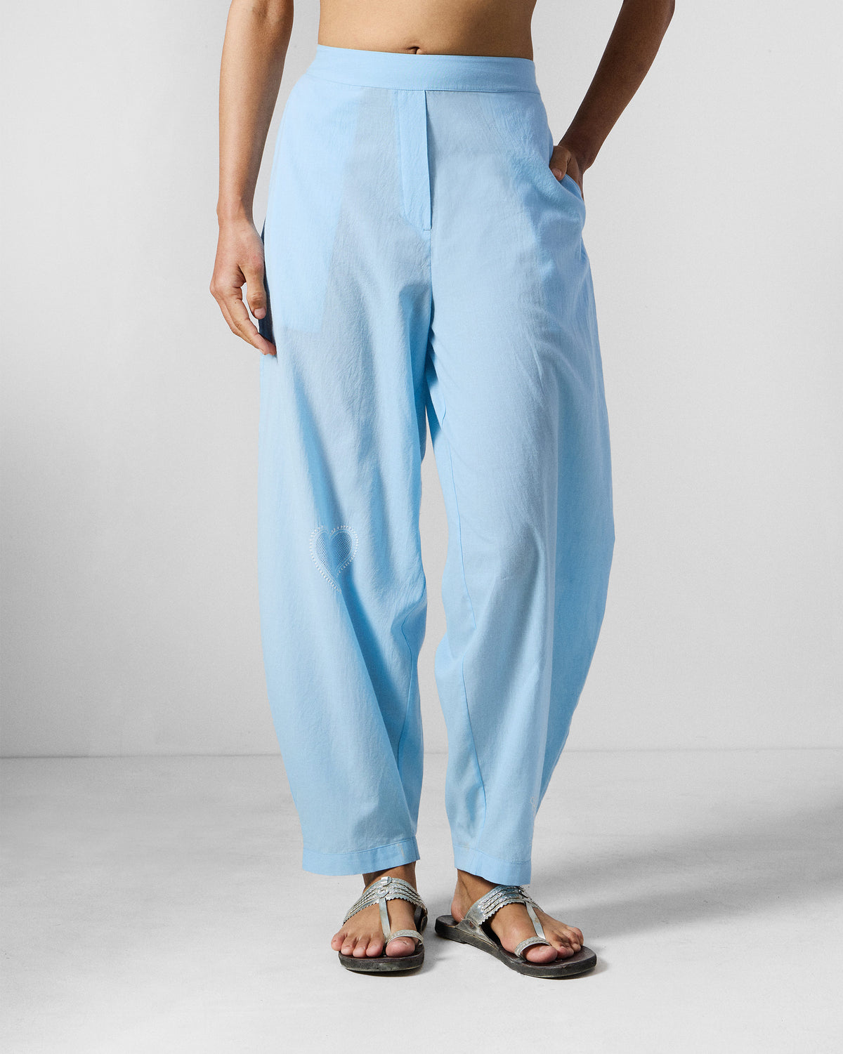 Person wearing ice blue Aaira Pants with a high waist and side pockets.