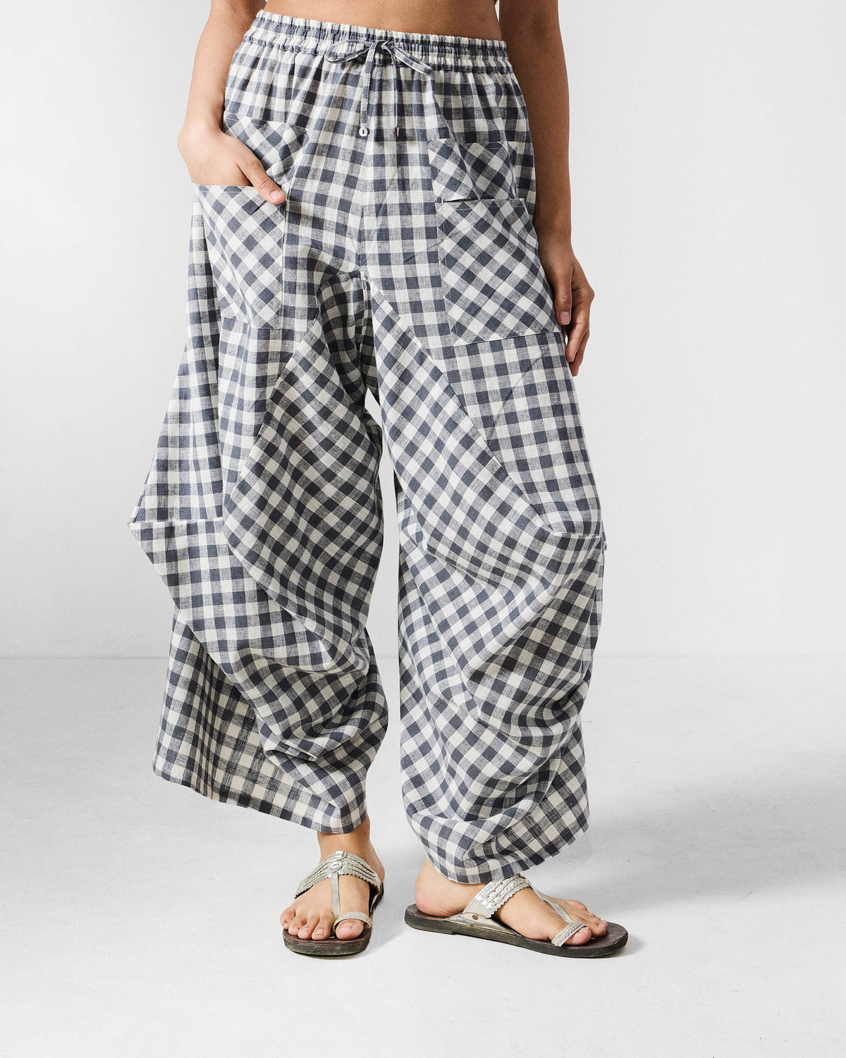 Grey and white checked Yoka trousers with a drawstring waist and patch pockets.