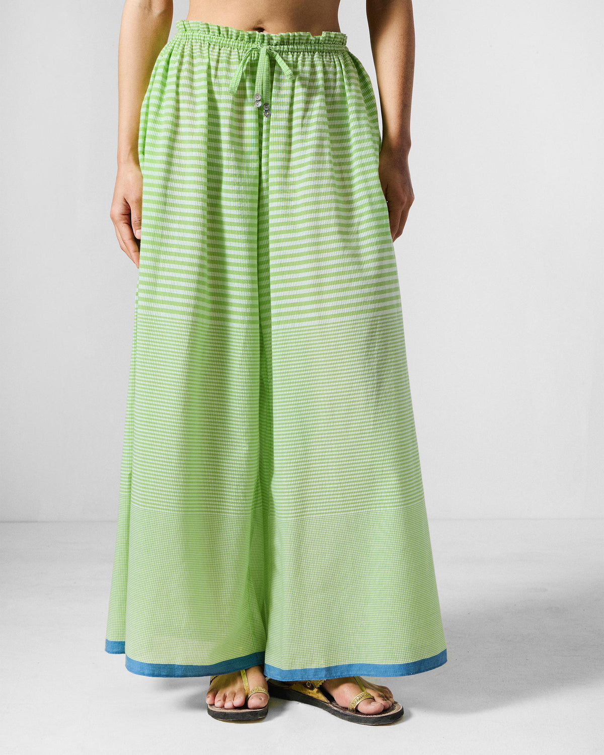 Person wearing light green and white check Paperbag Pants with a drawstring waist.