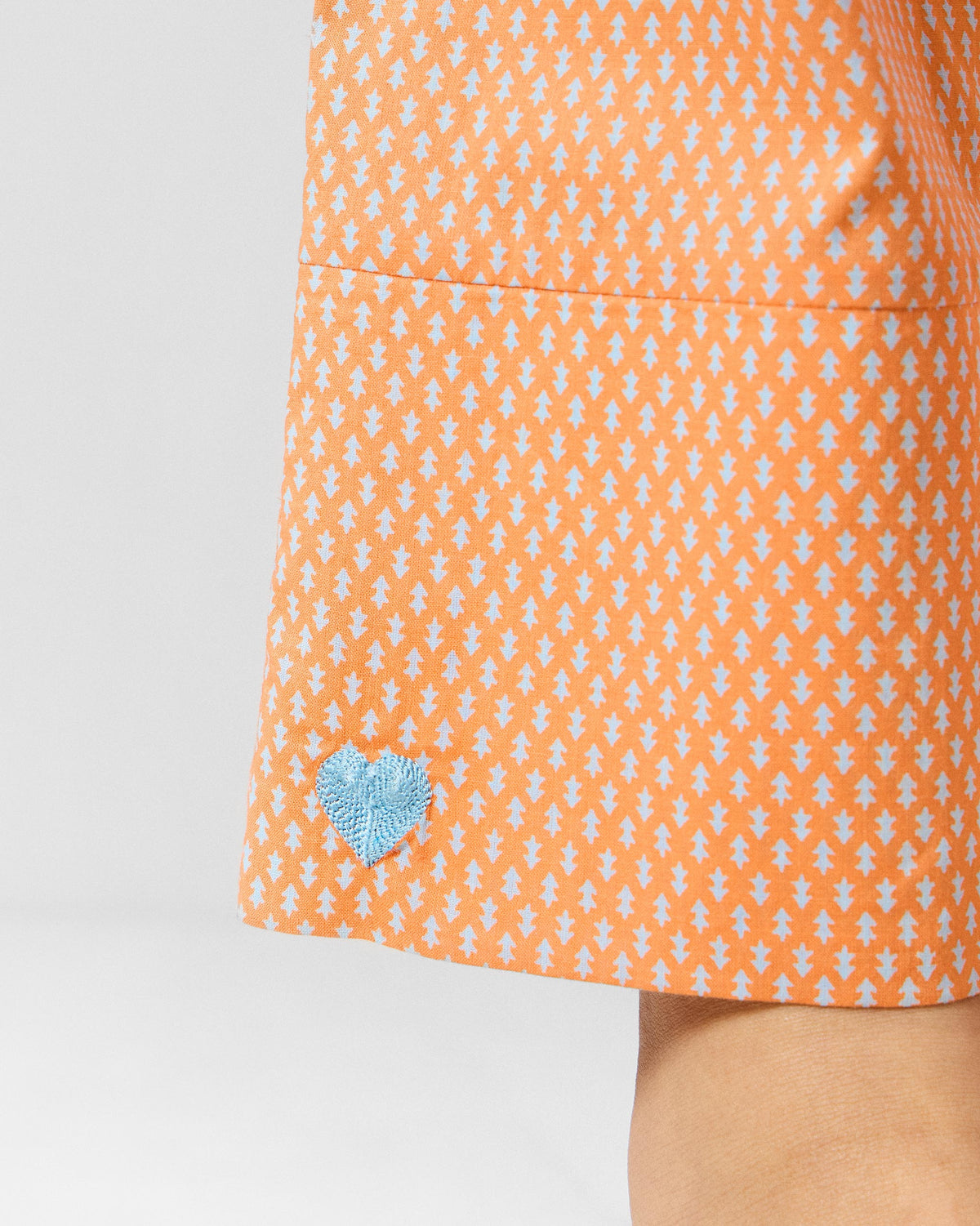 Close-up of a blue heart on orange printed Perch pants.