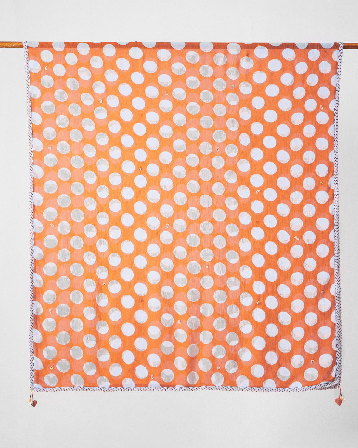 Full view of a Dot dupatta hung on a rod, showing its polka dot print.