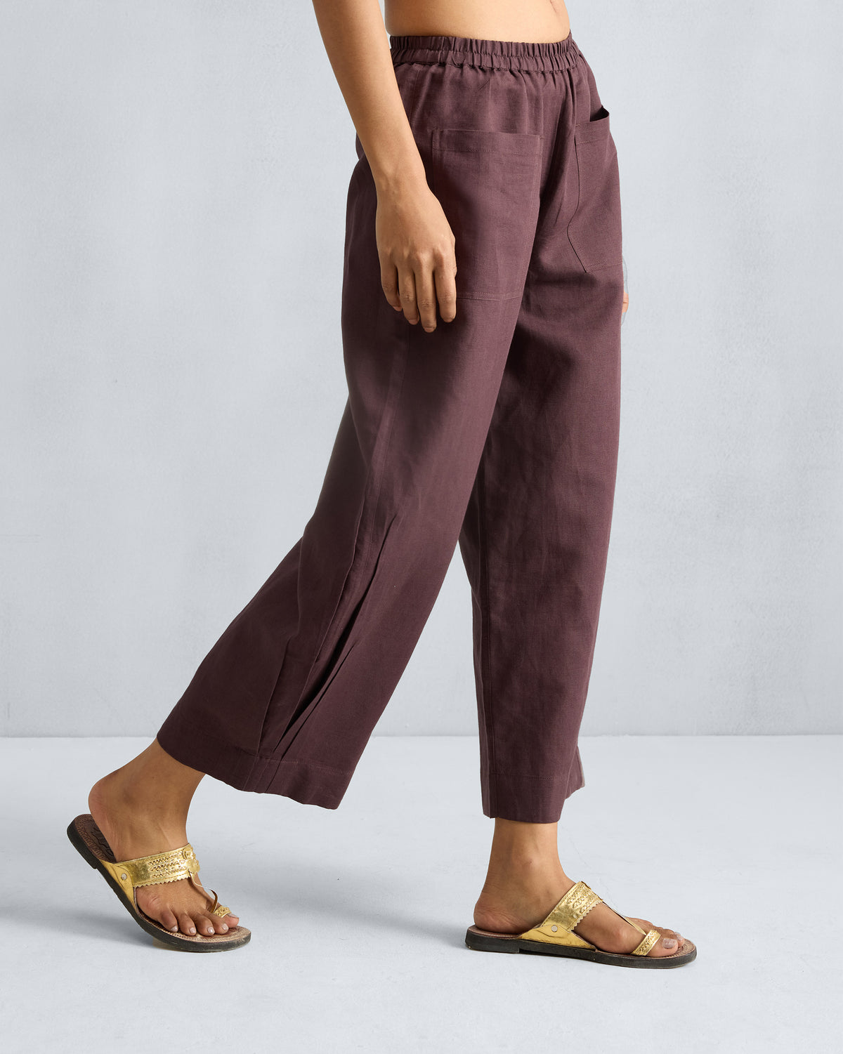 Side view of chocolate plum Serene pants showing a cropped wide-leg drape.