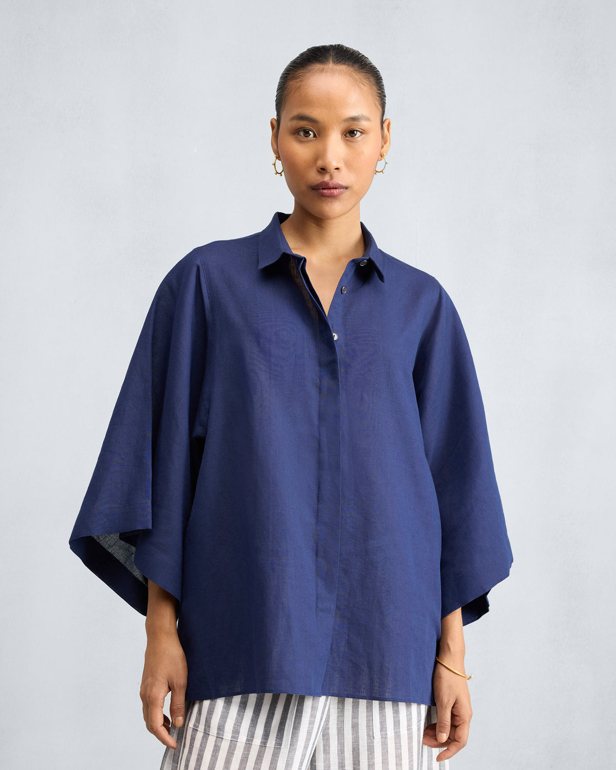 Person wearing an ink blue drop armhole shirt.