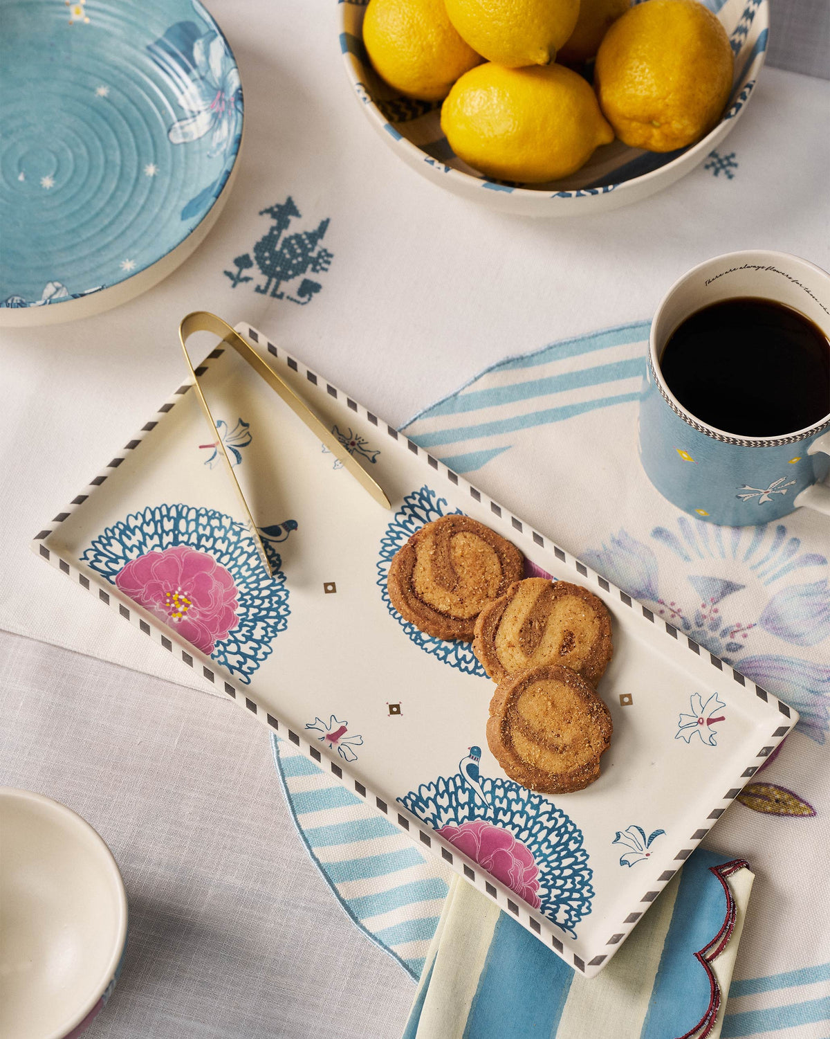 Marigold Cookie Tray With Tong holding cookies beside its gold tong.