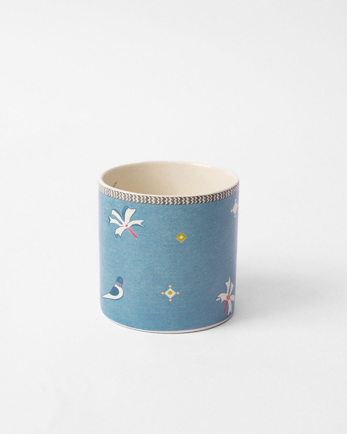Side view of the Parijat straight mug in blue with white and yellow motifs.