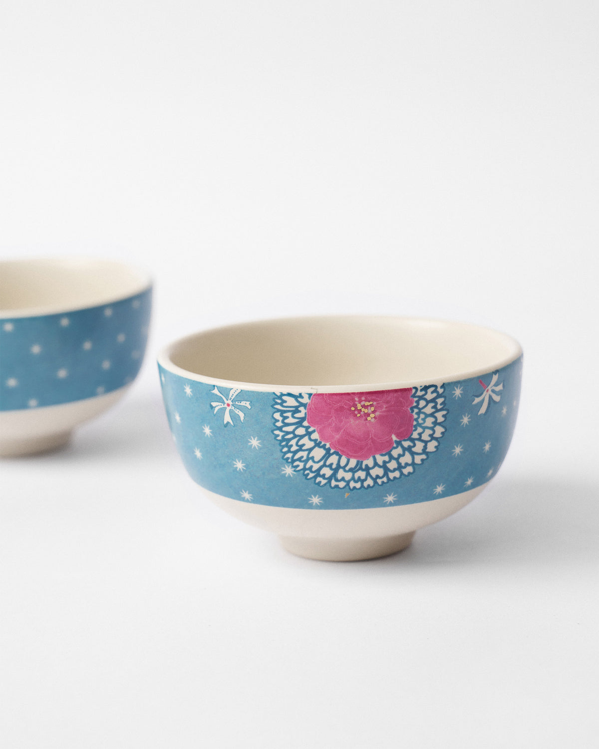 Close-up of a Marigold nibble bowl with a pink flower on blue.