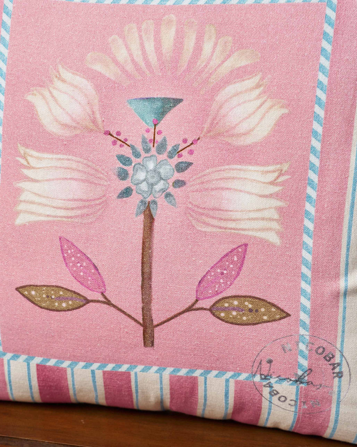 Close-up of the Lotus Stripes cushion cover showing the pink flower motif.