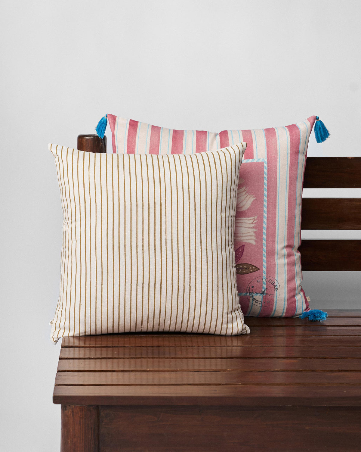 Cushion cover with thin gold and cream pinstripes.