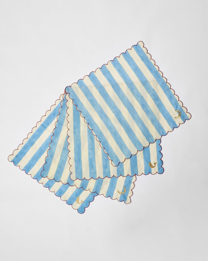 Four blue-and-cream striped napkins with red scalloped edges and gold motifs.