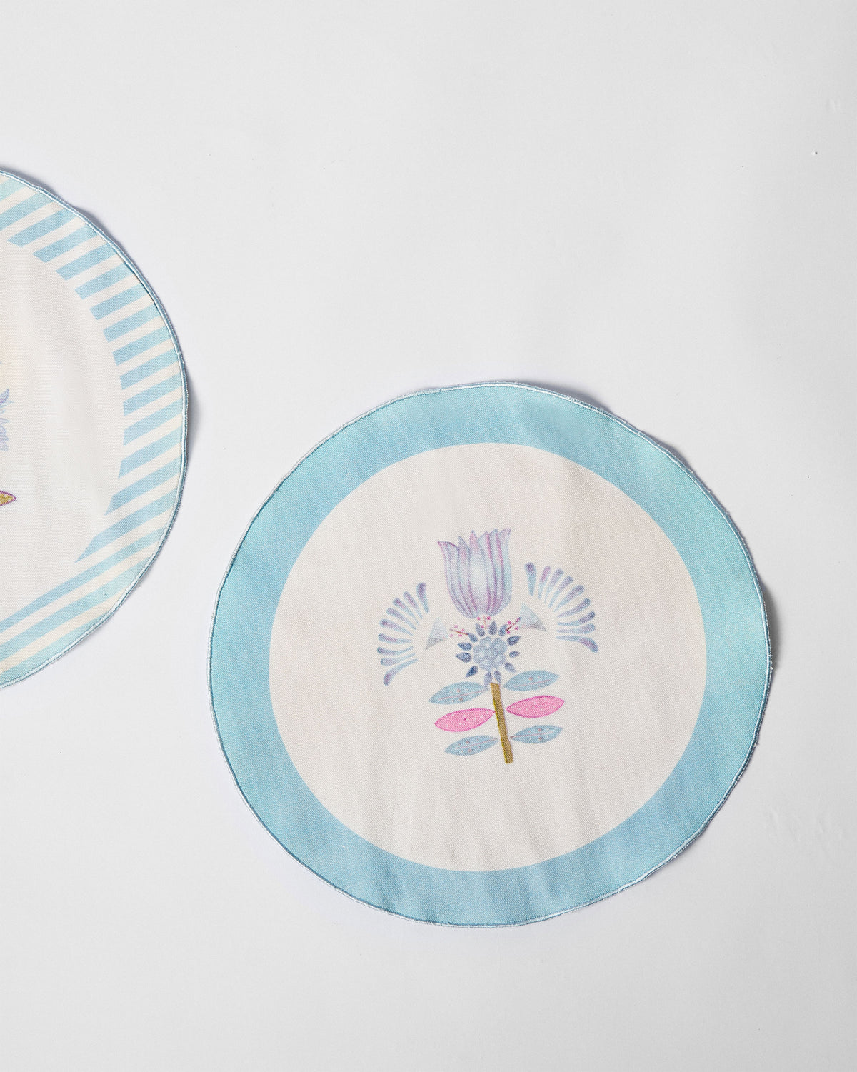 Close-up of a Lotus Placemat with a blue border and flower motif.