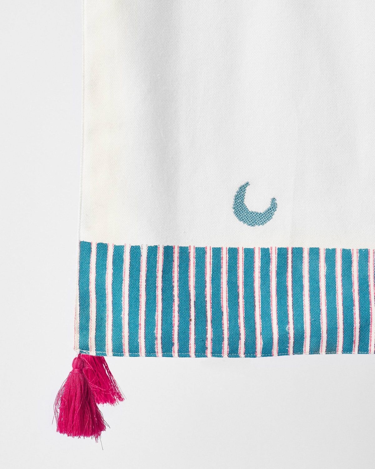 Close-up of the Mayur table runner end showing its striped border and tassels.