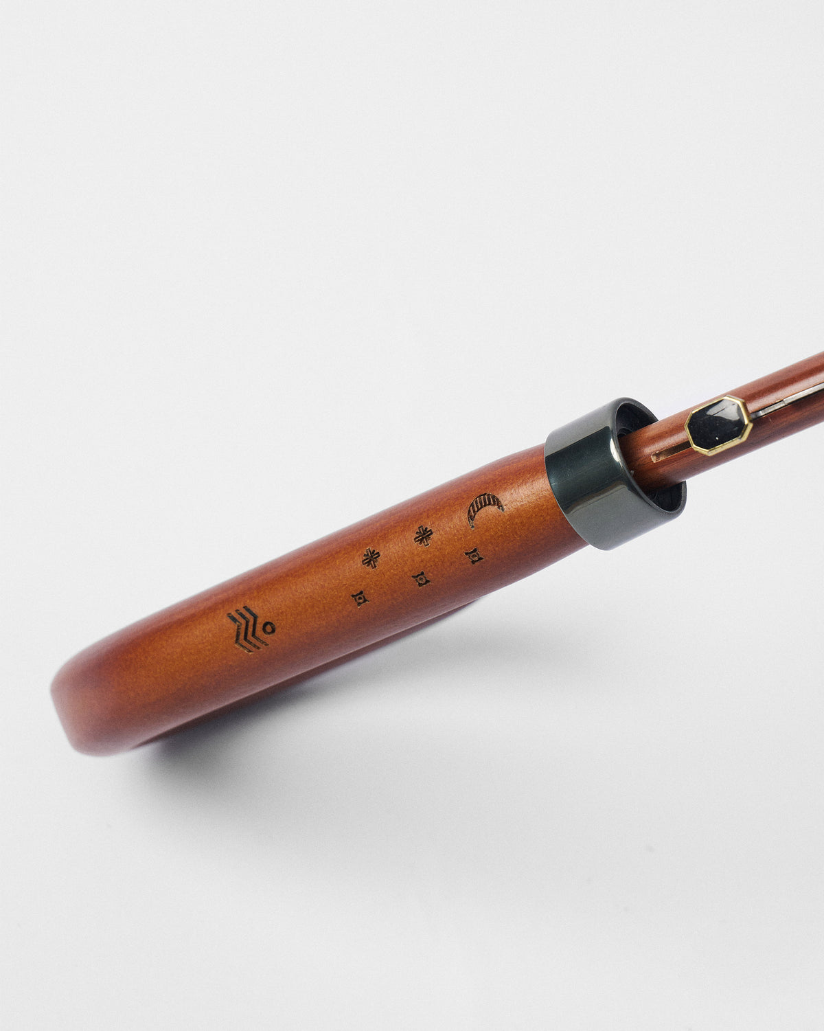 Close-up of the River Umbrella wooden handle with engraved marks and a metal collar.