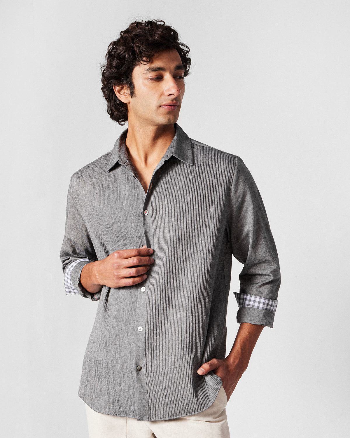 Charcoal Nava shirt worn with sleeves rolled to show gingham cuff linings.