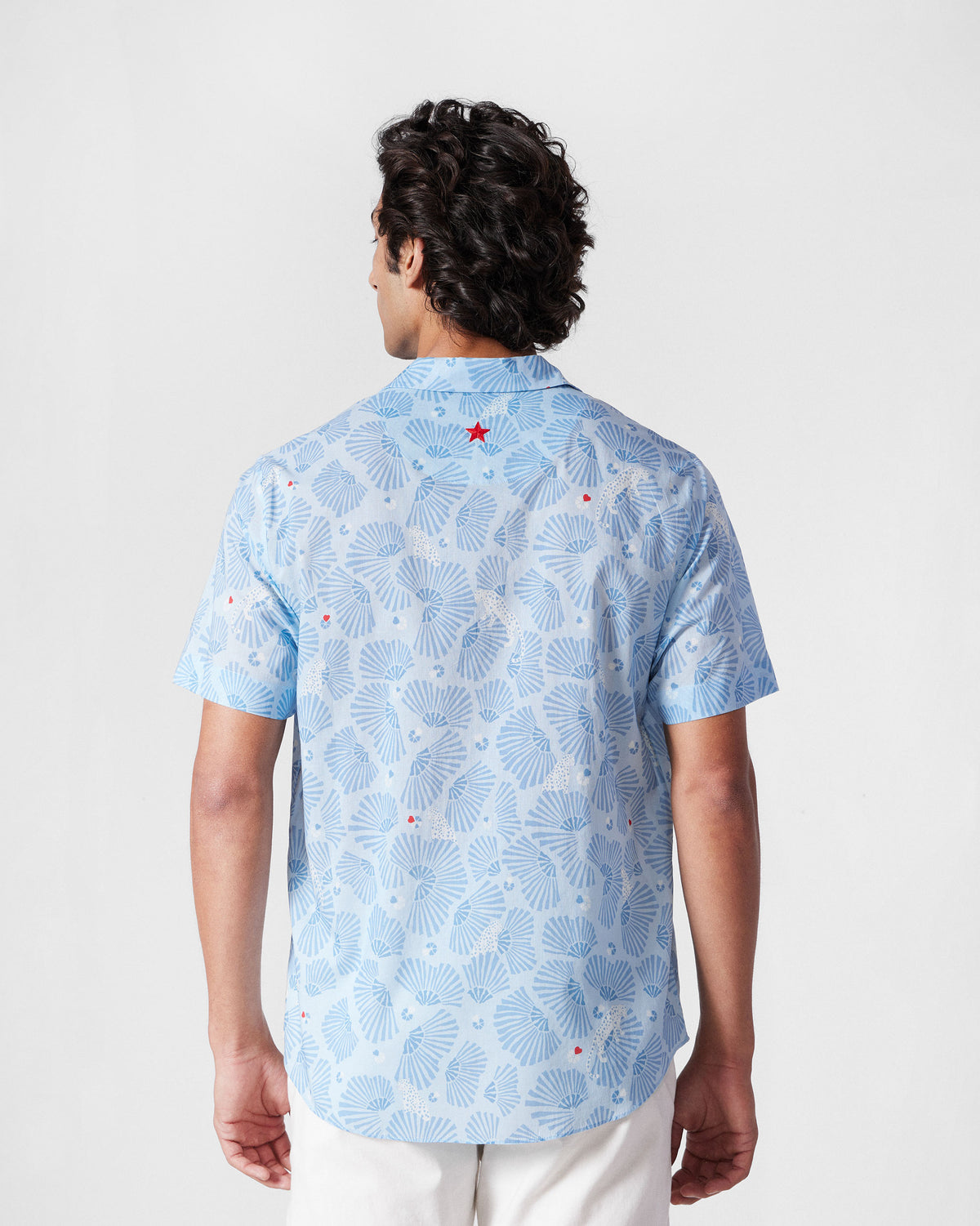 Back of a light blue Mistari shirt with a red star at the yoke.