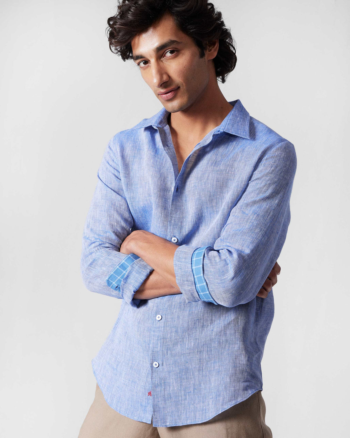 Person wearing a light blue linen Hakuna Shirt with a pointed collar.