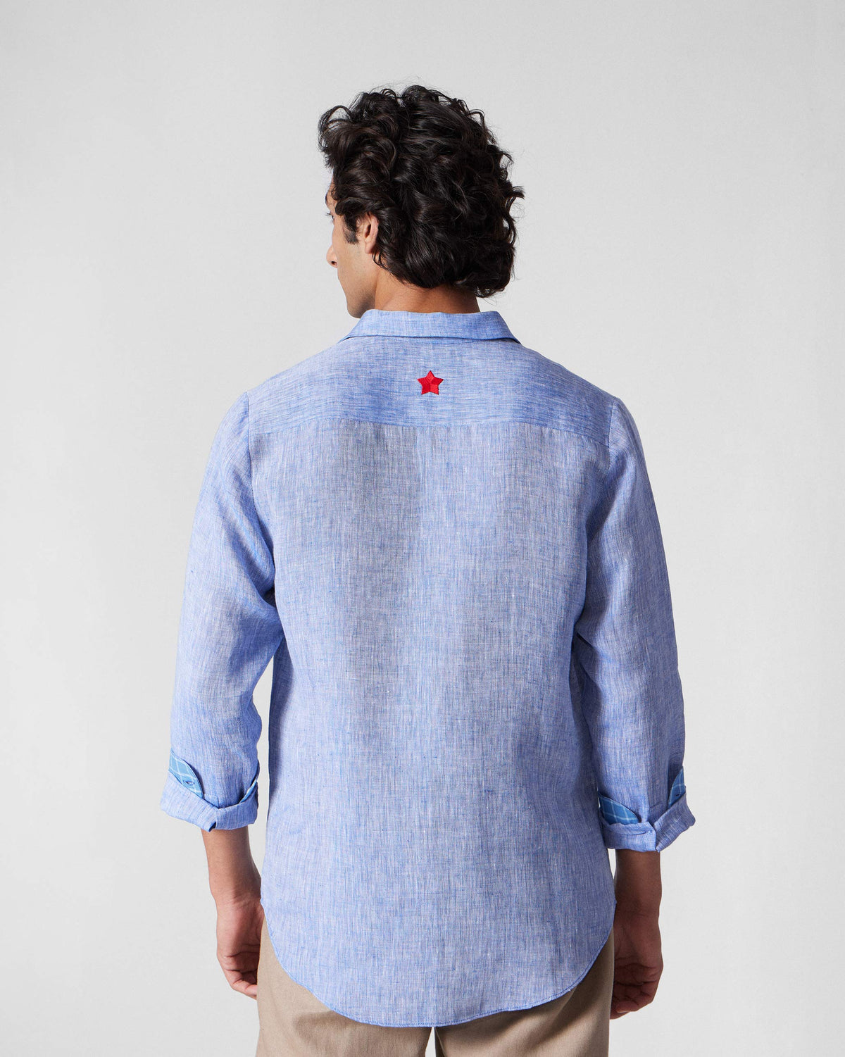 Back of a light blue Hakuna Shirt with a red star below the collar.