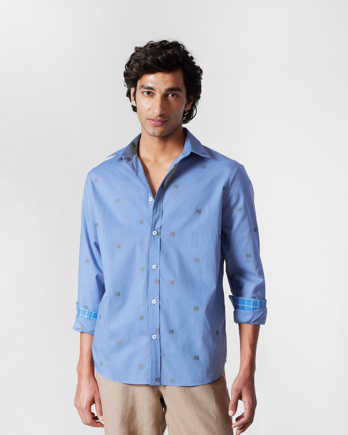 Person wearing a blue Sindhu Shirt with a small wavy motif print.