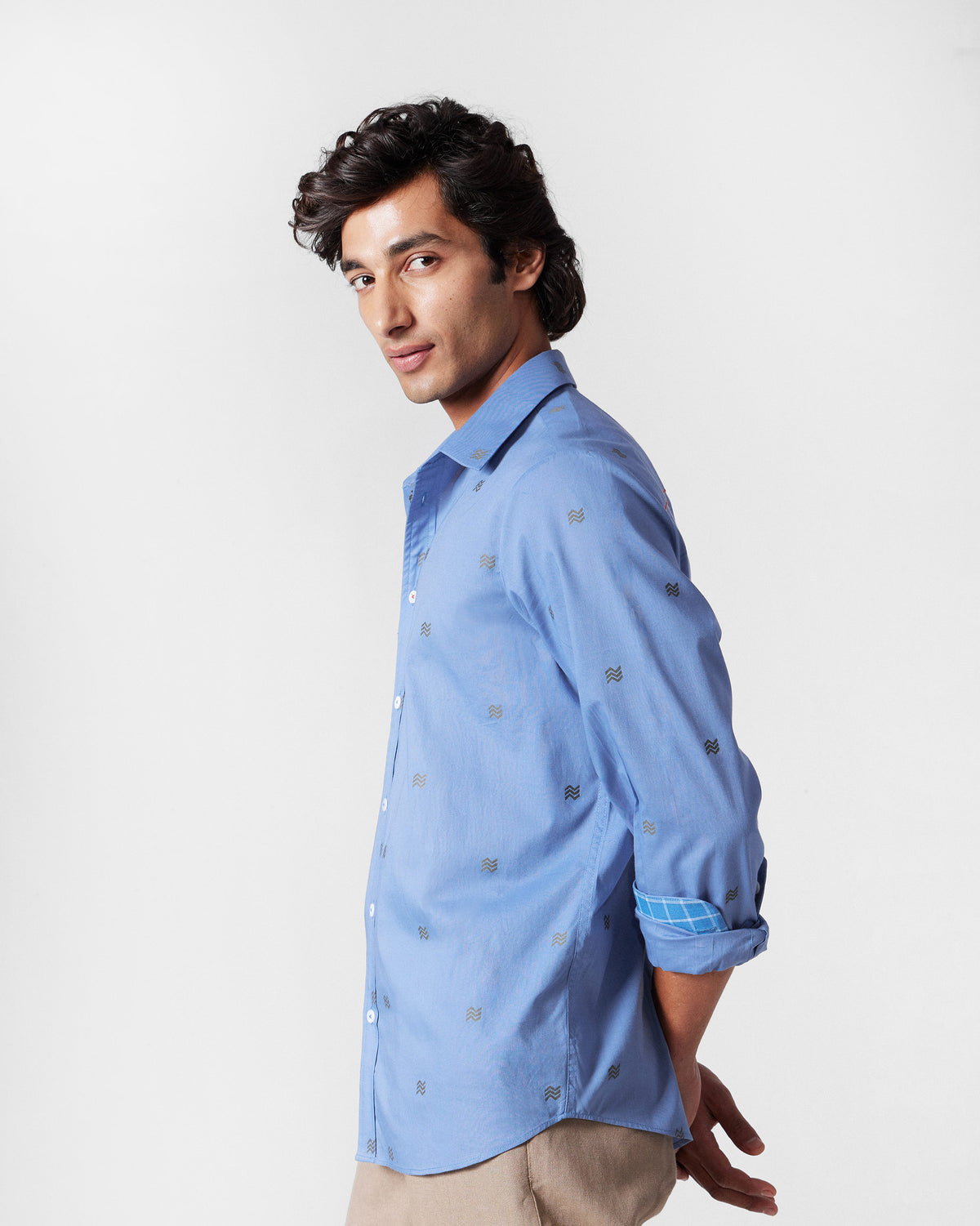 Side view of a blue Sindhu Shirt with a wavy motif print.