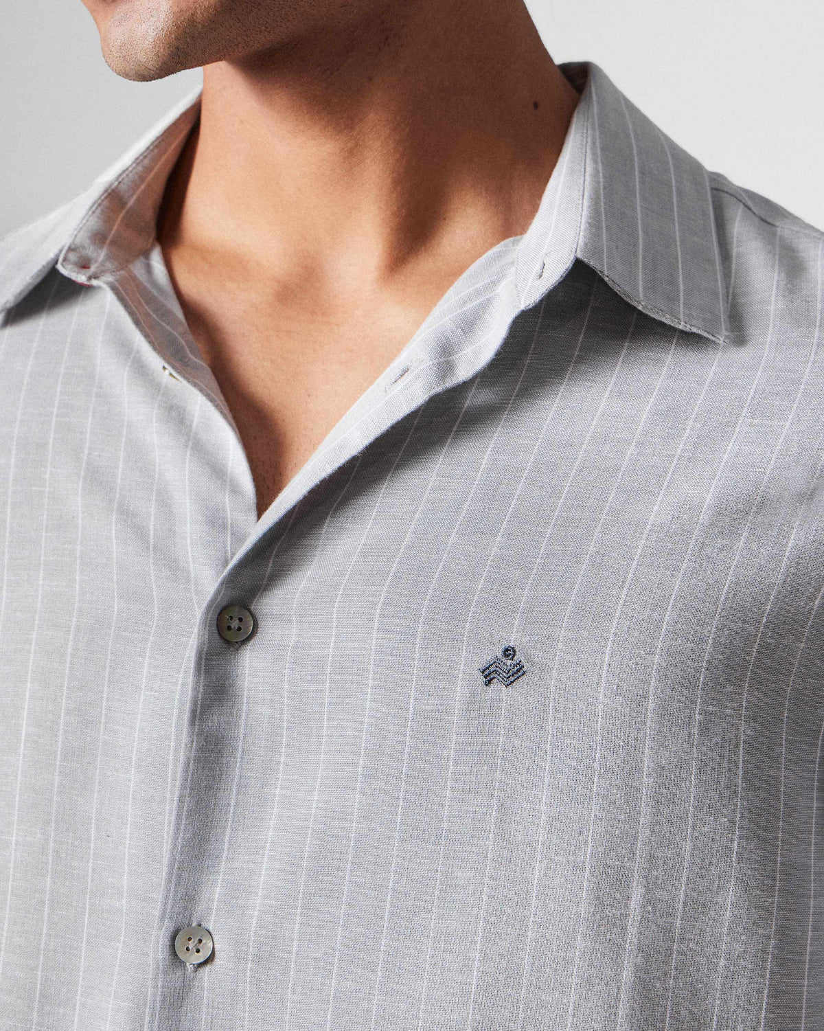 Close-up of a charcoal striped Silas Shirt with a small chest embroidery.
