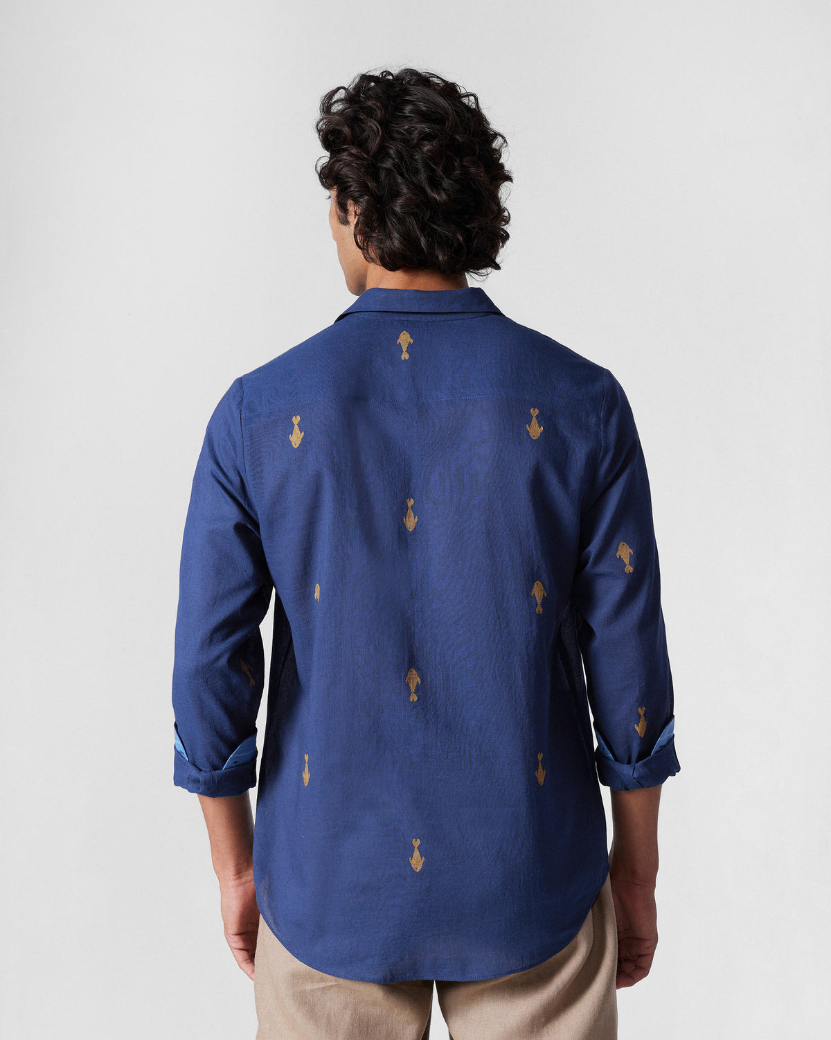 Back of a navy Hakuna Shirt with yellow fish motifs.