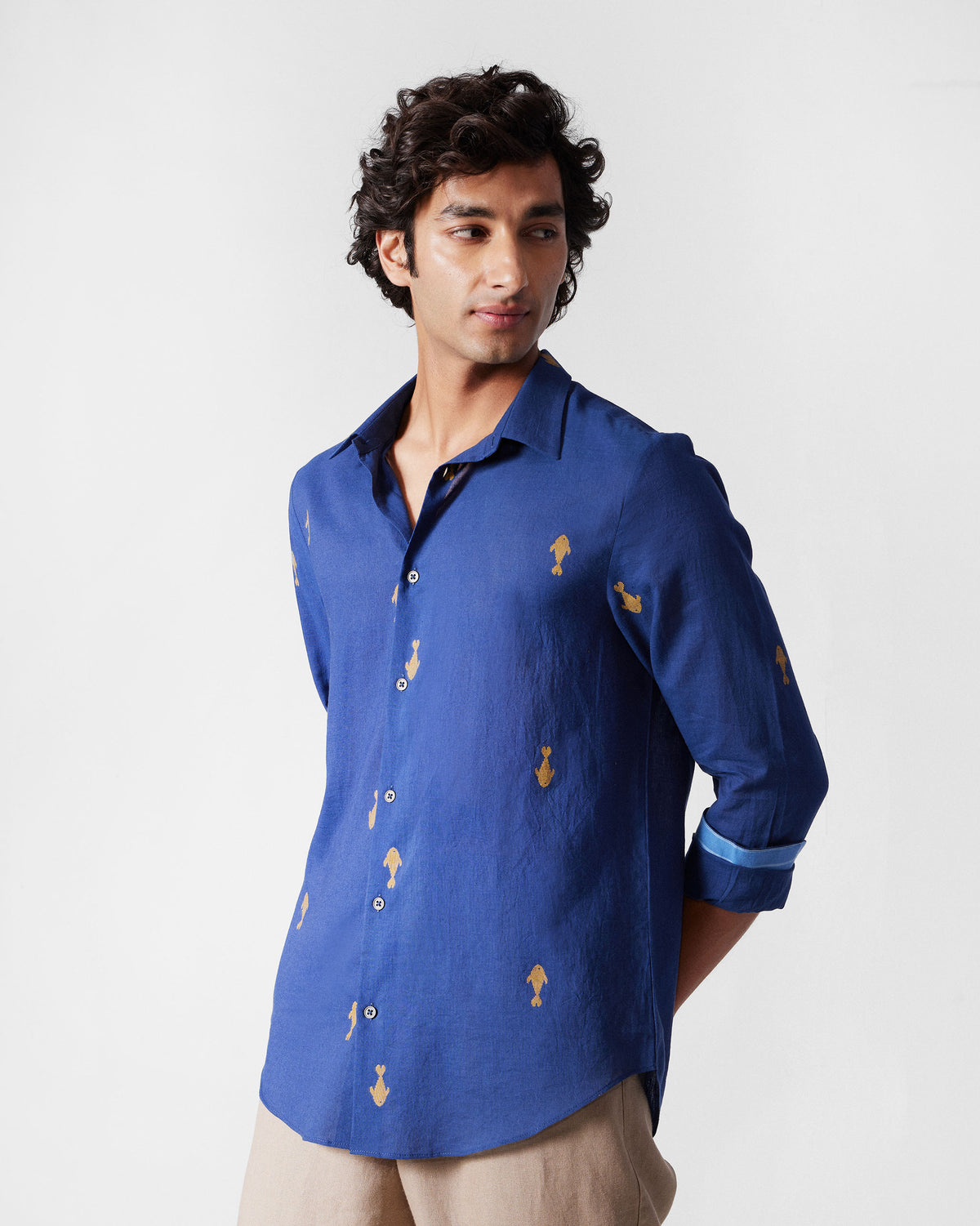 Person wearing a navy Hakuna Shirt with scattered yellow fish motifs.