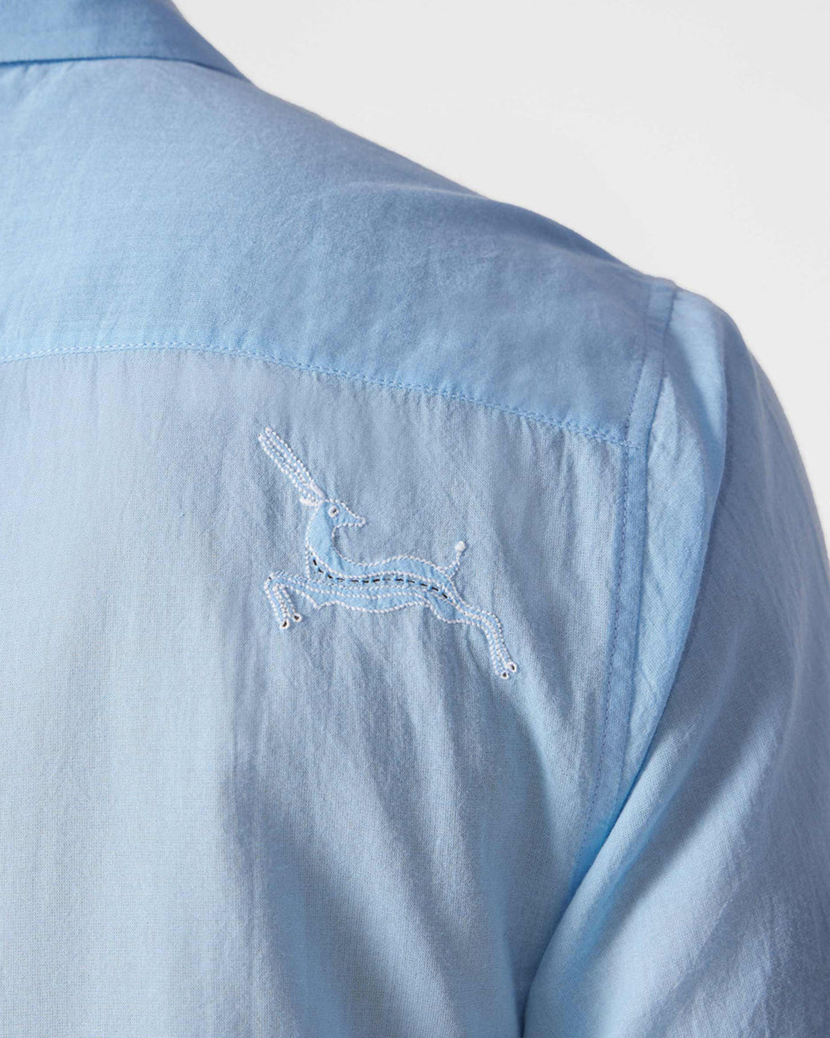 Close-up of a light blue Half Sleeve Shirt showing a white embroidered animal motif.
