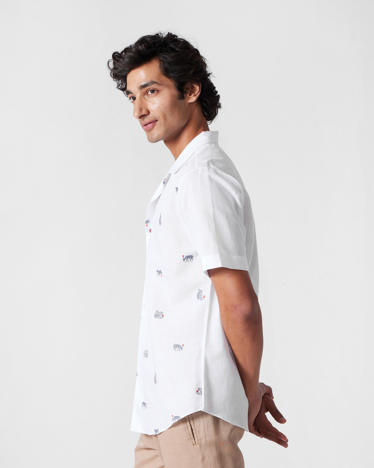 Side view of a white Mistari Shirt with embroidered animal motifs.