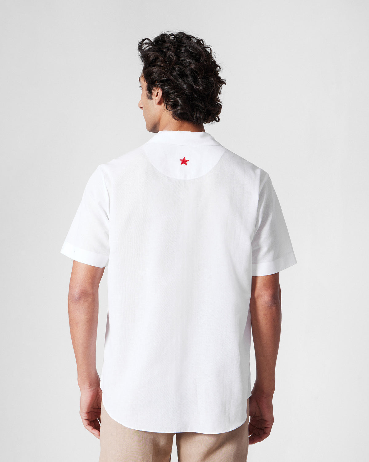 Back of a white Mistari Shirt with a red star at the yoke.