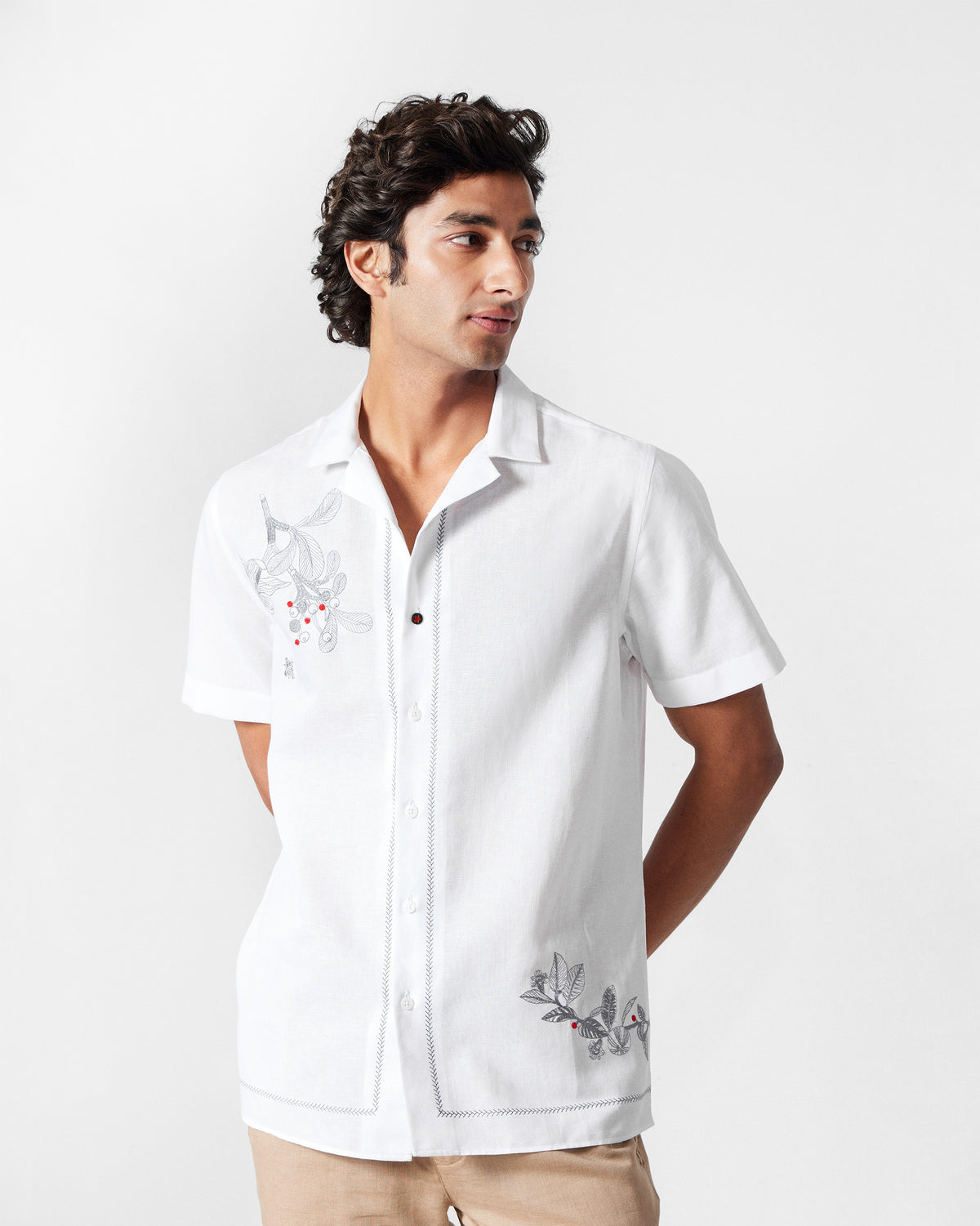 Person wearing a white Delta shirt with berry floral embroidery.